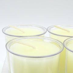 Clear plastic cups with white candle on a white background