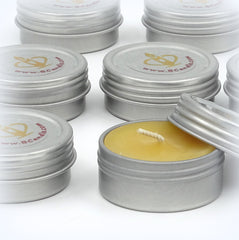 Silver tins with candles inside on a white background