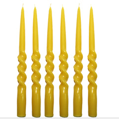 Set of six yellow twisted candles on a white background