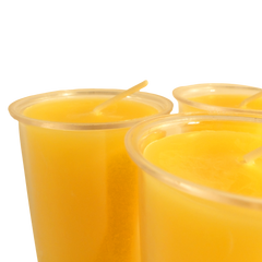 Yellow candles in clear containers on a white background