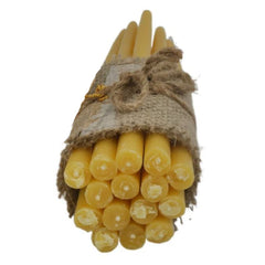 A bundle of natural yellow beeswax candles tied with burlap twine, next to a kraft paper tag for Jordanville Candles on a white background.
